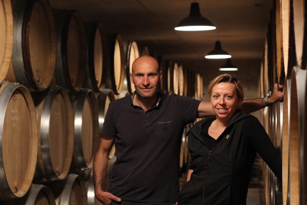 Pierre-Yves Colin-Morey & Caroline Morey standing together in a barrel chai.